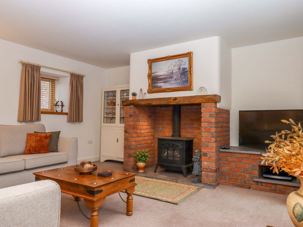 A living room with a fireplace and sofa at Grange Cottage in Coldridge