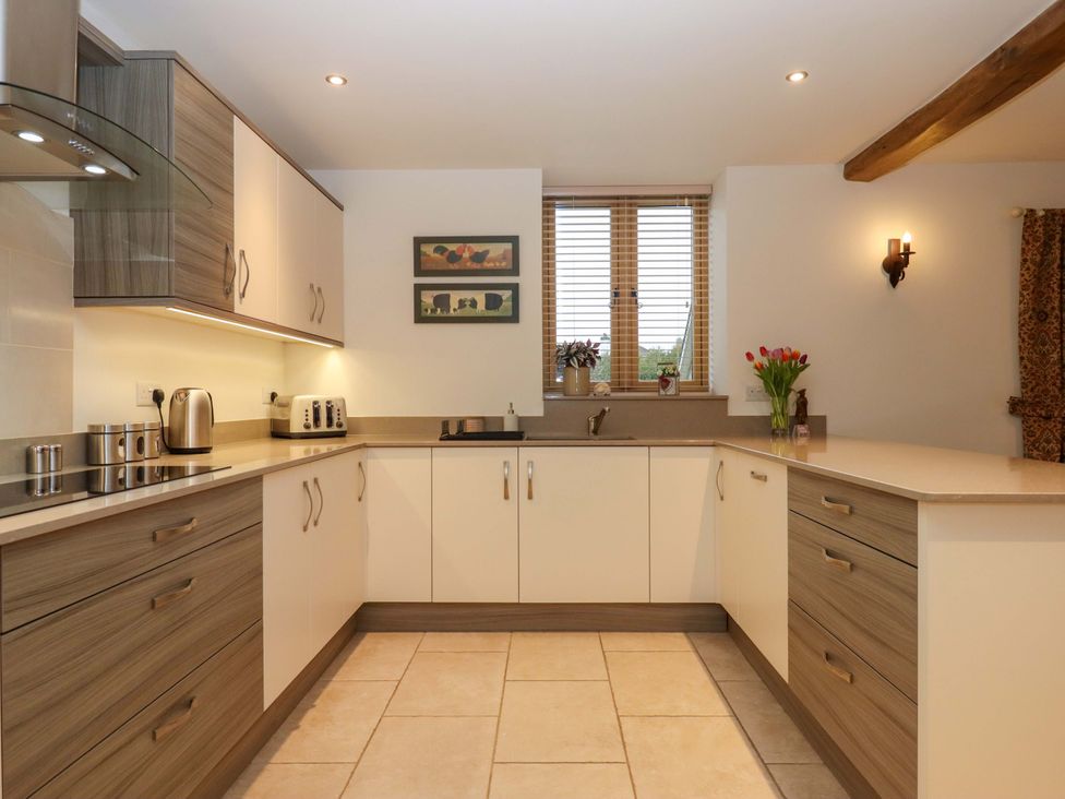 A kitchen with cabinets, counter, sink and kettle at Grange Cottage in Coldridge
