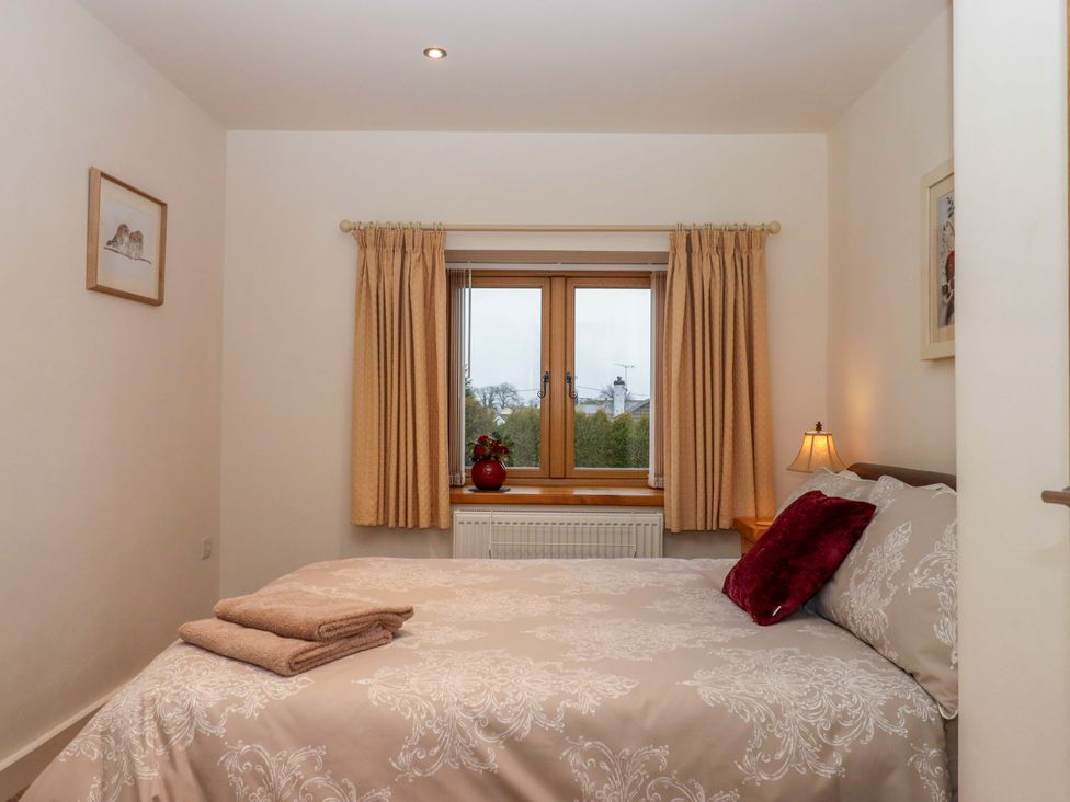A bedroom with a bed and window at Grange Cottage Coldridge