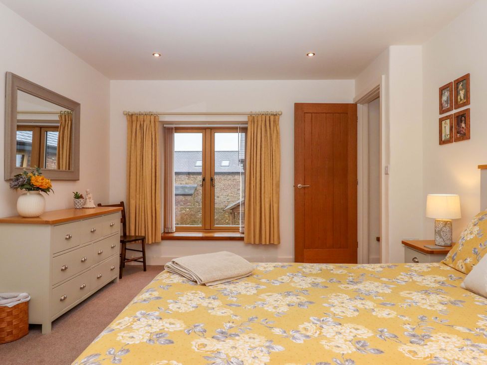A bedroom with a bed and dresser at Grange Cottage Coldridge