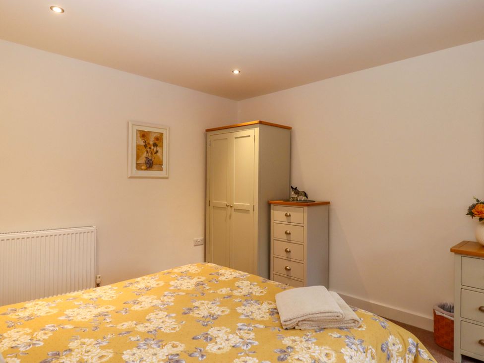 A bedroom with a bed and wardrobe at Grange Cottage in Coldridge