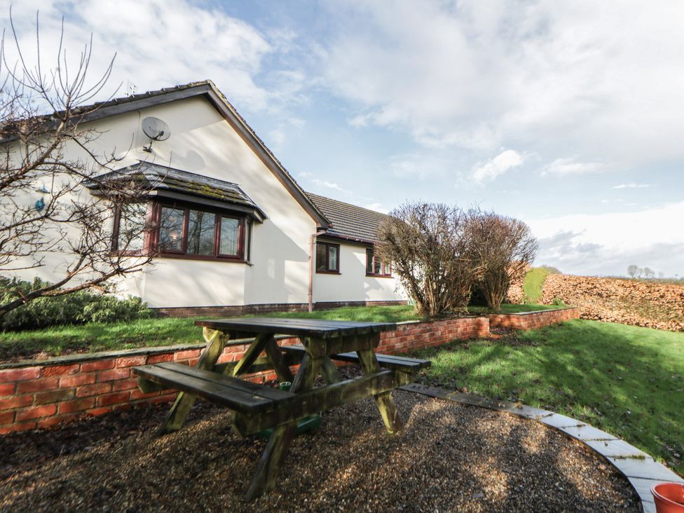 A garden with a picnic table and bushes at Summerhill in Hereford