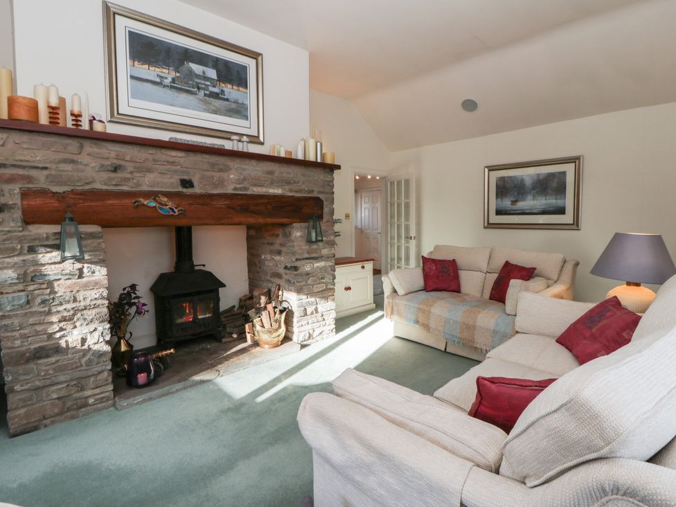 A living room with a fireplace and sofas at Summerhill in Hereford