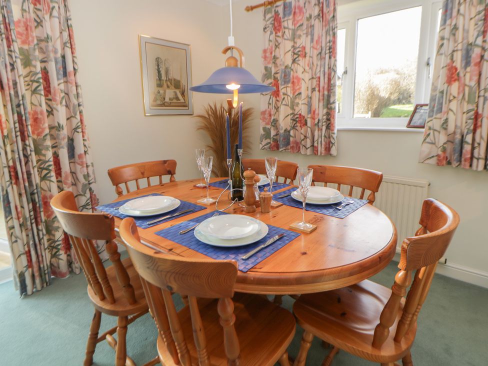 A dining room with a round table set for meals at Summerhill Hereford