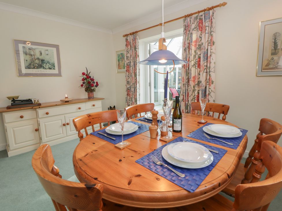 A dining room with a round wooden table set for dinner at Summerhill Hereford