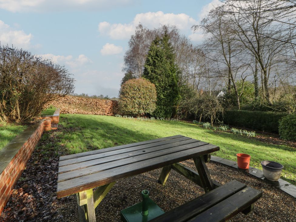 A garden with benches and trees at Summerhill in Hereford