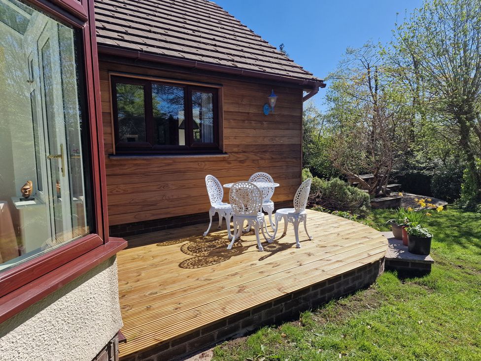 An outdoor seating area with a table and chairs at Summerhill Near Glasbury