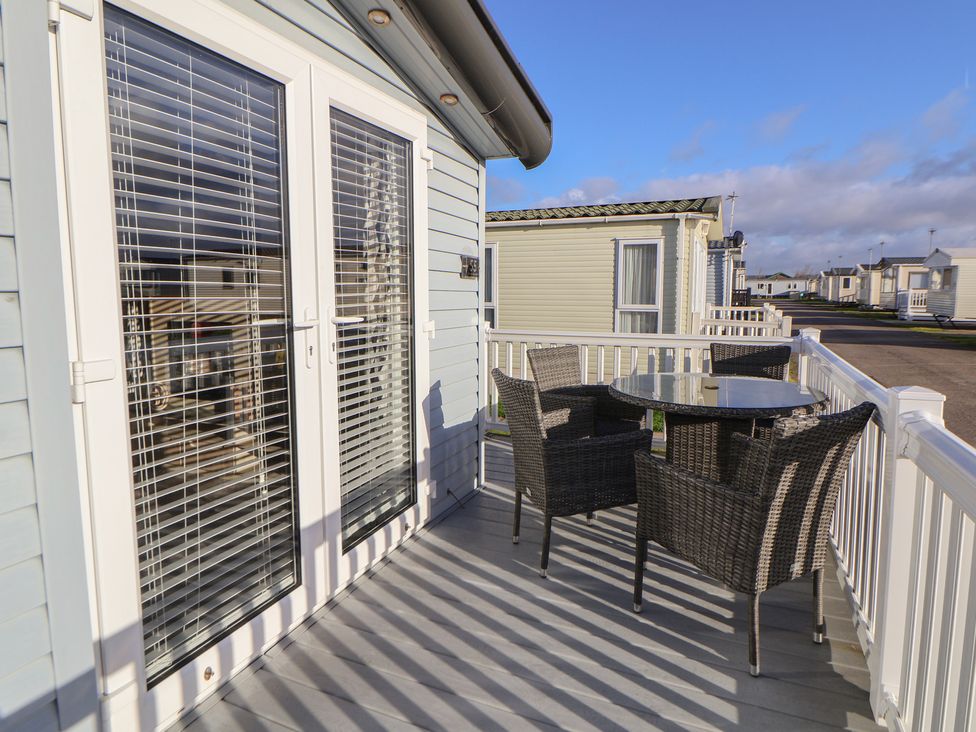 A deck with a table and chairs at CG 55