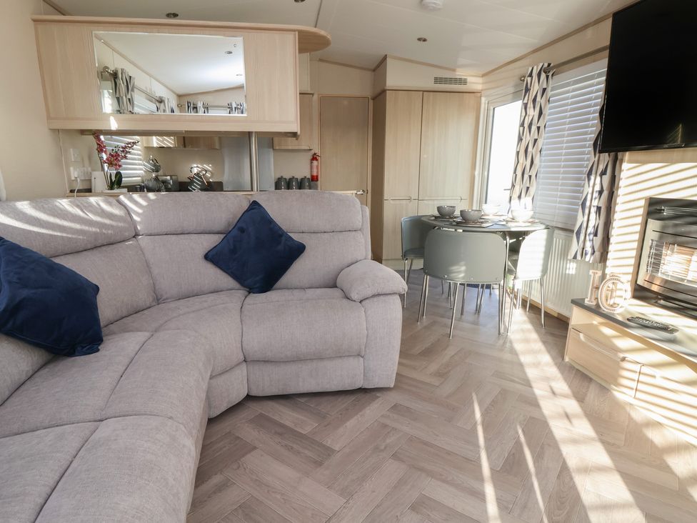 A living room with a sofa and dining area at CG 55