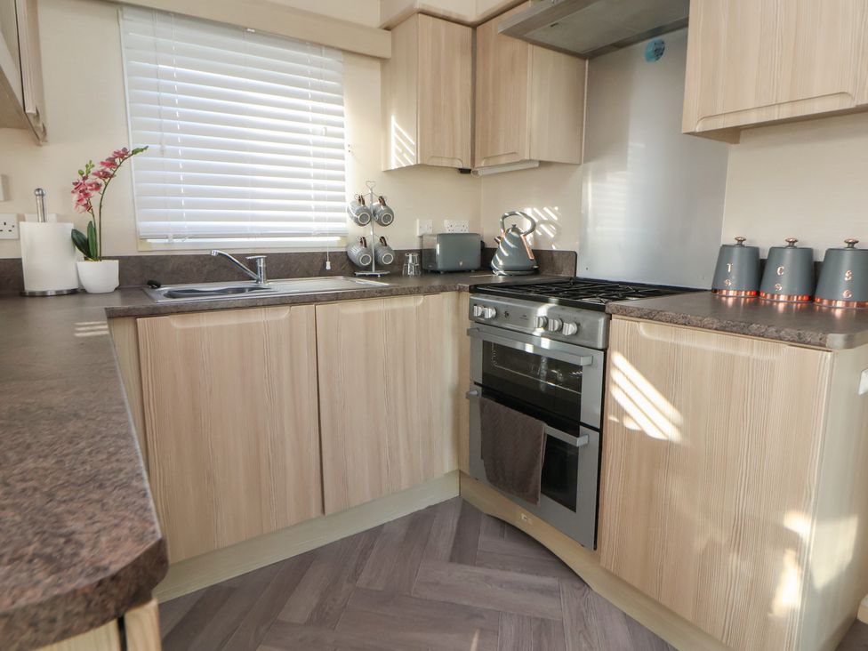 A kitchen with sink stove and cabinets at CG 55