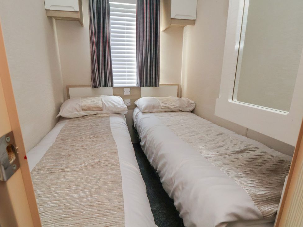 A bedroom with two single beds and a window at CG 55