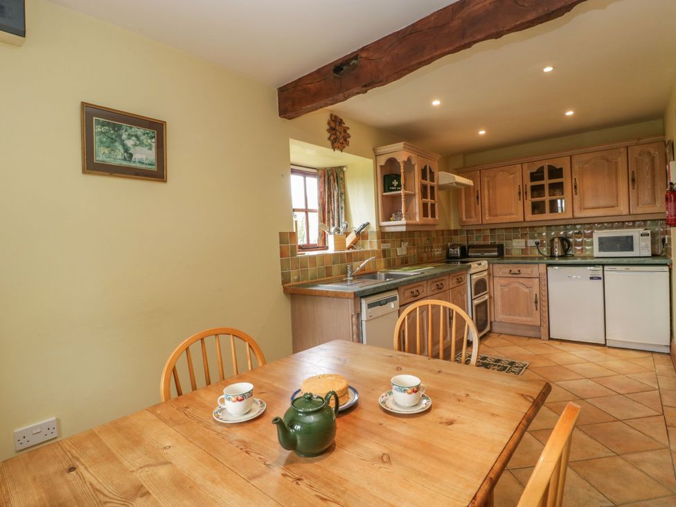 A kitchen with a table and chairs at The Stables in Sturminster Newton