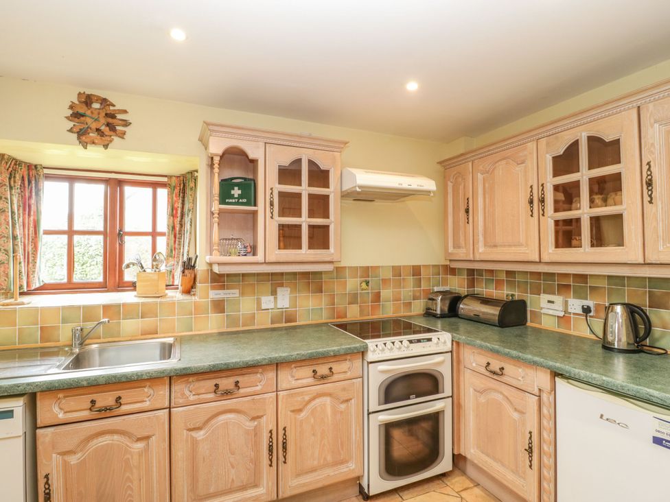 A kitchen with cabinets and appliances at The Stables in Sturminster Newton