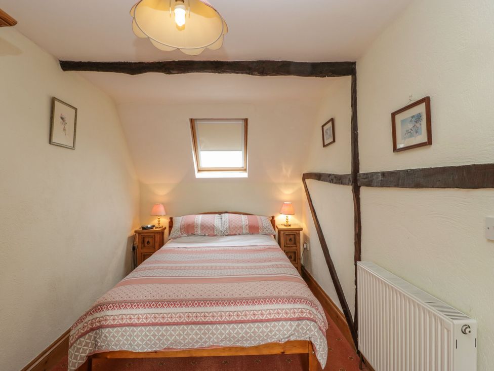 A bedroom with a bed and nightstands at The Stables in Sturminster Newton