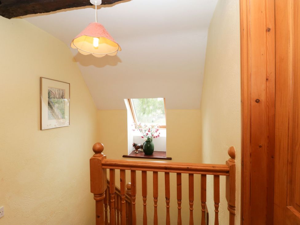 A hallway with a staircase and a window at The Stables in Sturminster Newton
