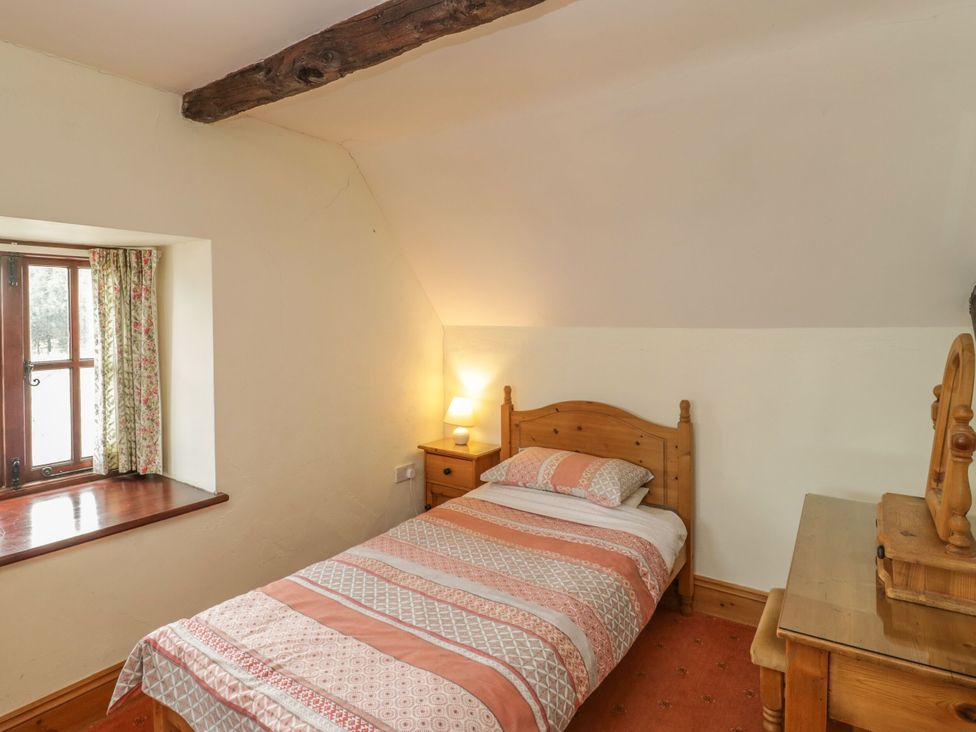 A bedroom with a bed and a window at The Stables in Sturminster Newton