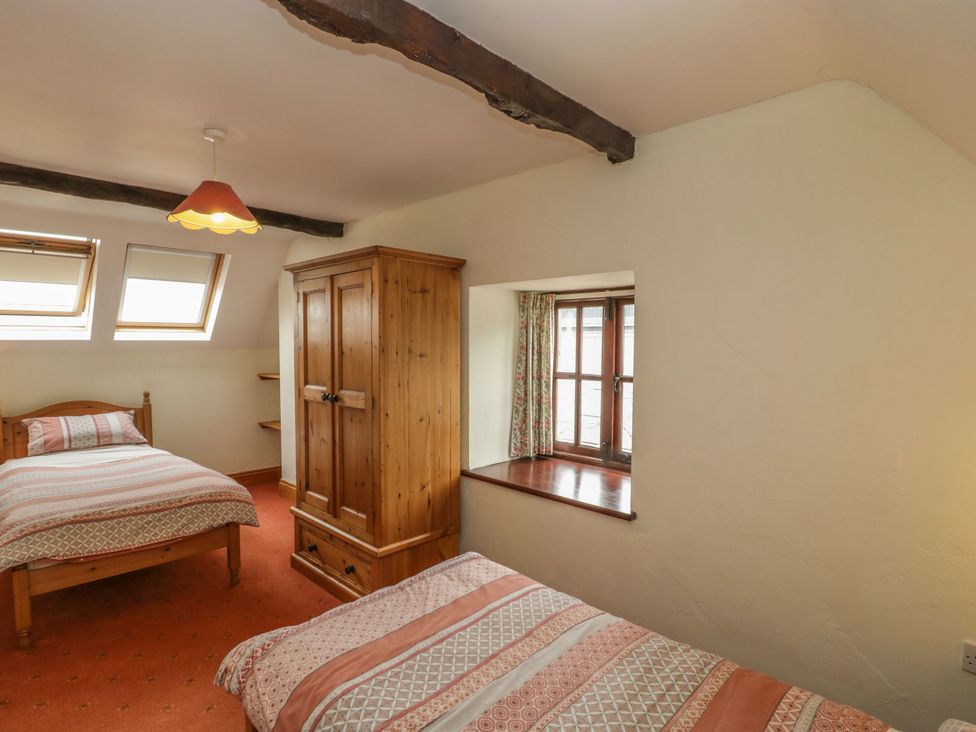 A bedroom with two beds and a wardrobe at The Stables in Sturminster Newton