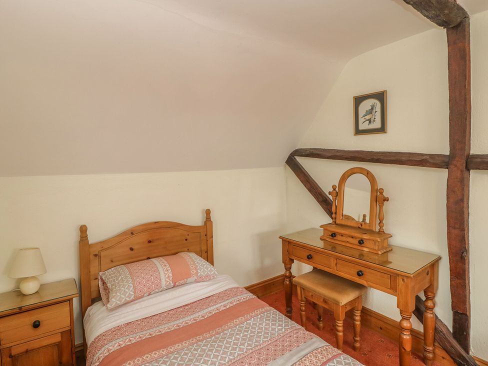 A bedroom with a bed and dressing table at The Stables in Sturminster Newton