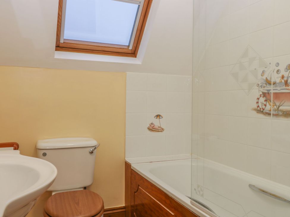 A bathroom with a bathtub, toilet, and sink at The Stables in Sturminster Newton