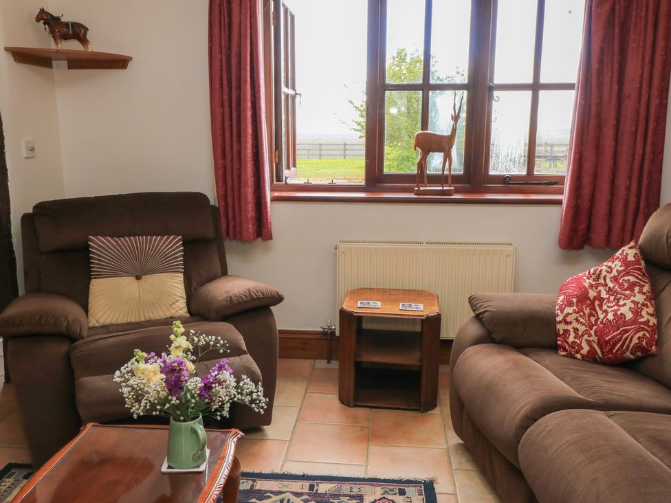 A living room with a sofa and coffee table at The Stables in Fifehead Neville near Hazelbury Bryan