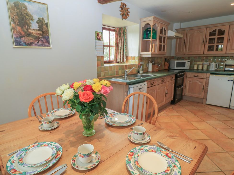 A kitchen with a table set for meals at The Stables in Fifehead Neville near Hazelbury Bryan
