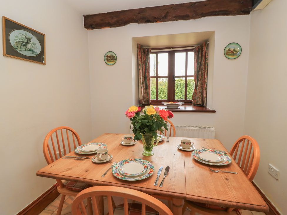 A dining room with a table set for a meal at The Stables in Fifehead Neville near Hazelbury Bryan