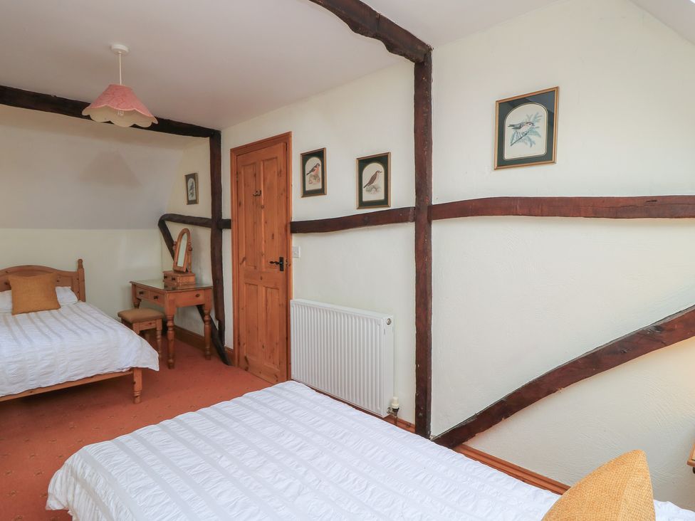 A bedroom with two beds and a vanity table at The Stables in Fifehead Neville near Hazelbury Bryan