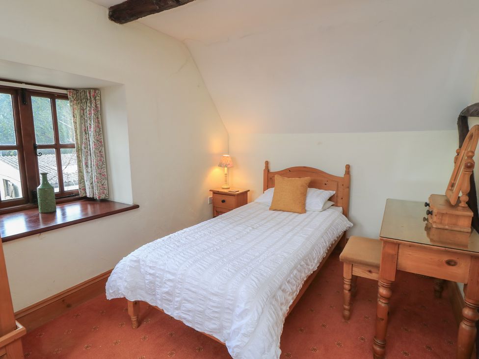A bedroom with a single bed and wooden furniture at The Stables in Fifehead Neville near Hazelbury Bryan
