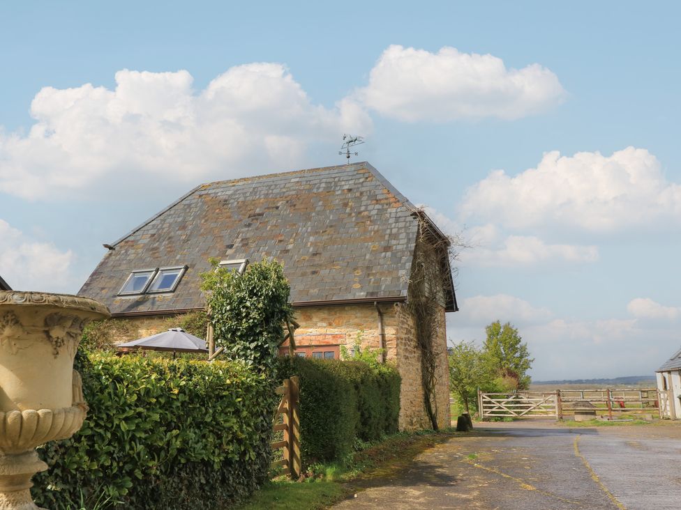 A house with a stone exterior and a slate roof at The Stables near Fifehead Neville