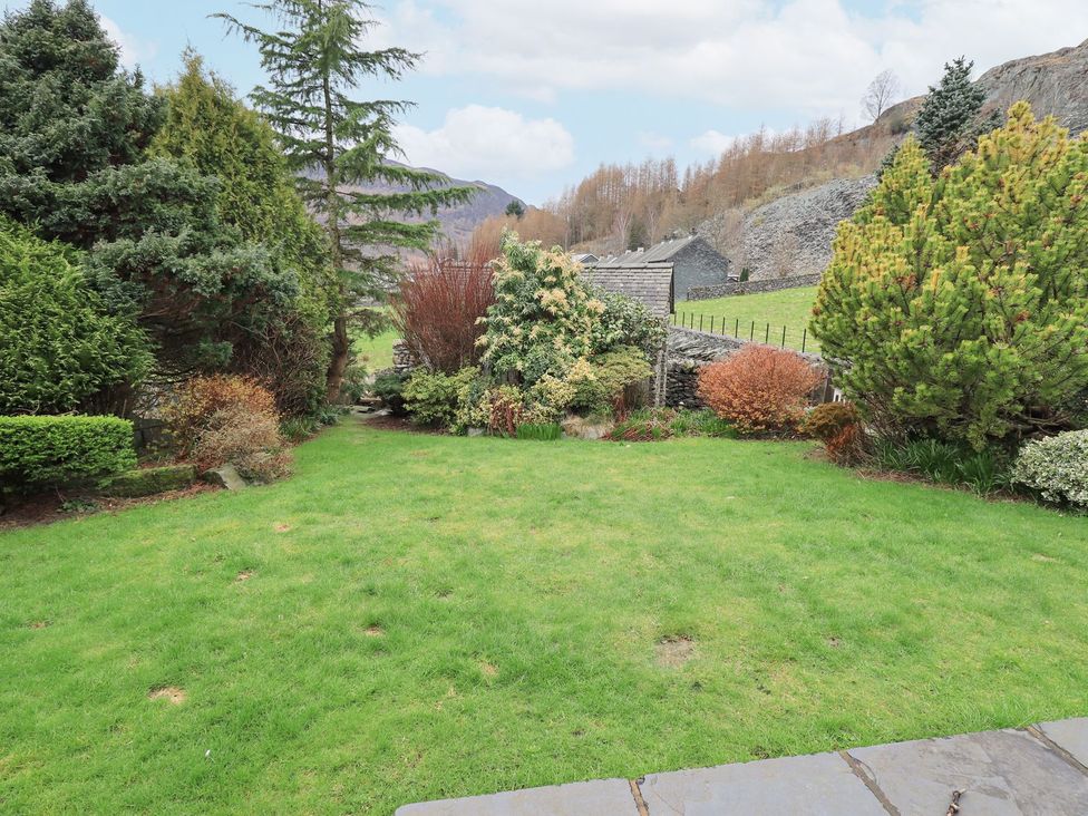 A garden with grass and various trees and shrubs at Thrang View in Chapel Stile