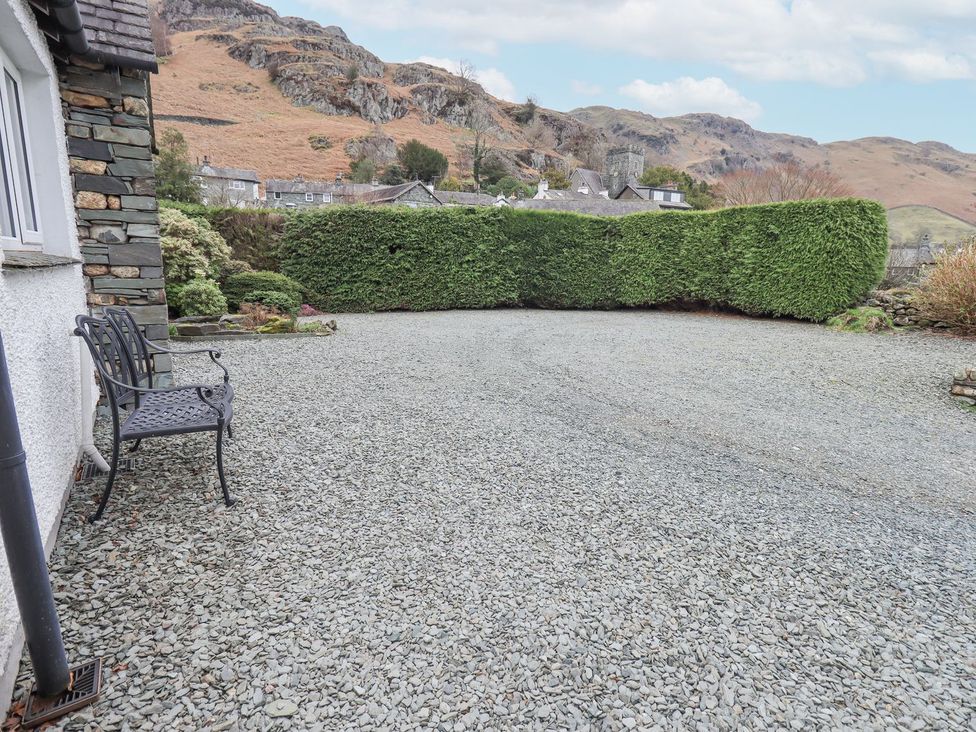 An outdoor space with gravel, a bench, and a hedge at Thrang View in Chapel Stile