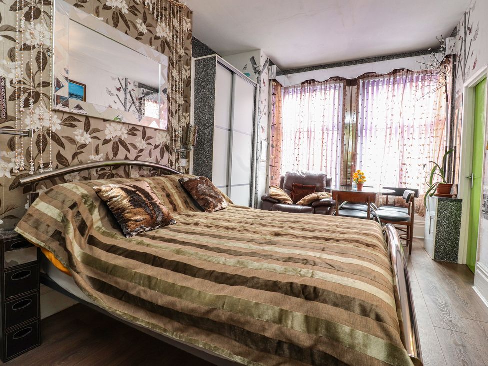 A bedroom with a bed and a seating area at Number 3 Blackpool