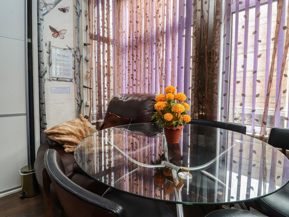 A dining room with a glass table and a sofa at Number 3 Blackpool