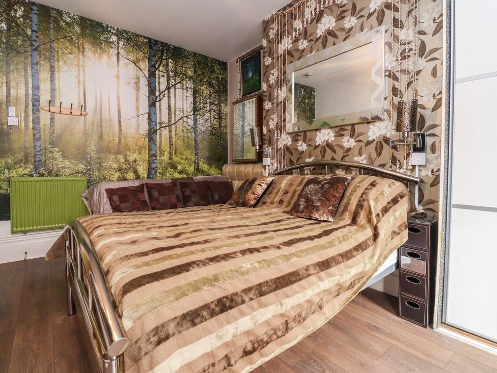 A bedroom with a bed and a forest wallpaper at Number 3 Blackpool