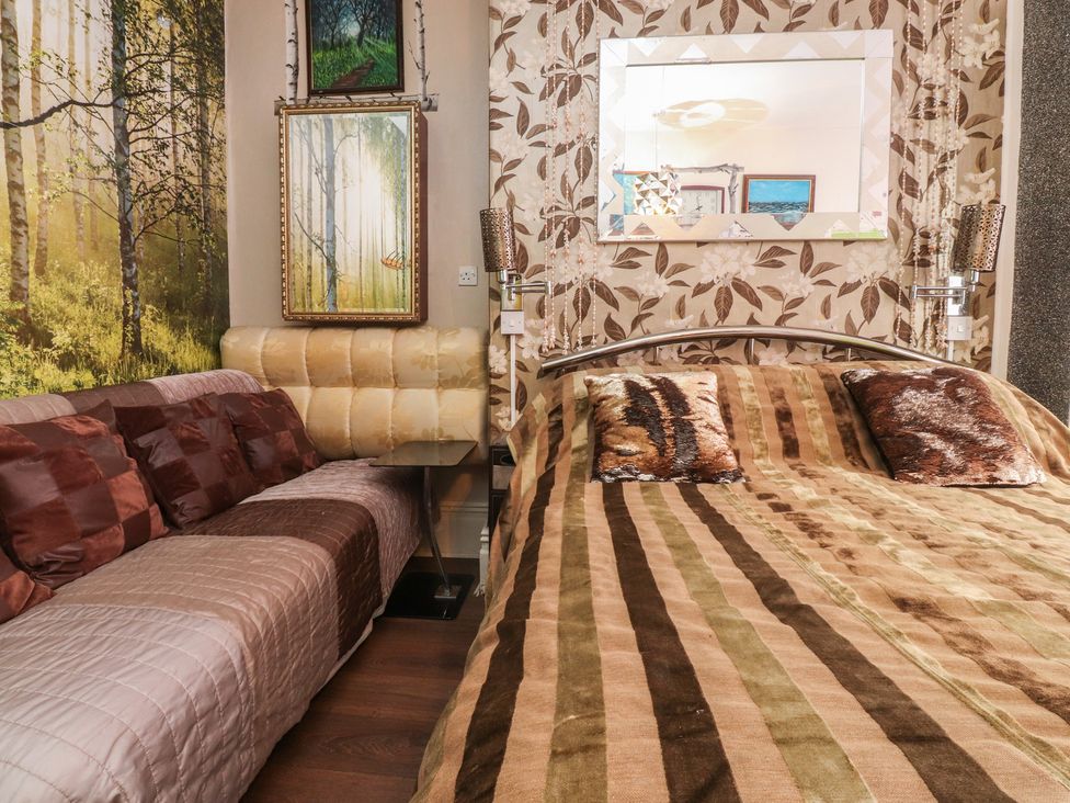 A bedroom with a bed and a sofa at Number 3 in Blackpool