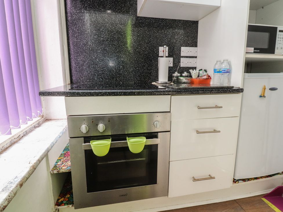 A kitchen with an oven, refrigerator, and sink at Number 3 in Blackpool