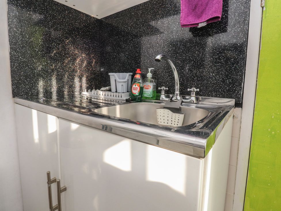 A kitchen with a sink and dish rack at Number 3 Blackpool