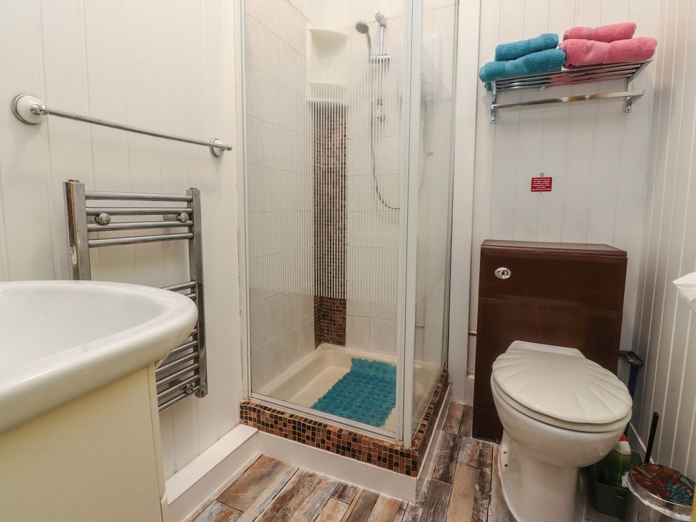 A bathroom with a shower and towels on a rack at Number 3 Blackpool