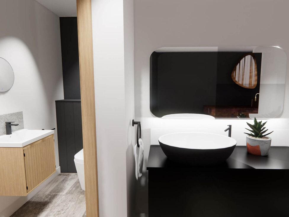A bathroom with a sink, toilet, and mirror at Arvo Suite 1.0 in Marhamchurch