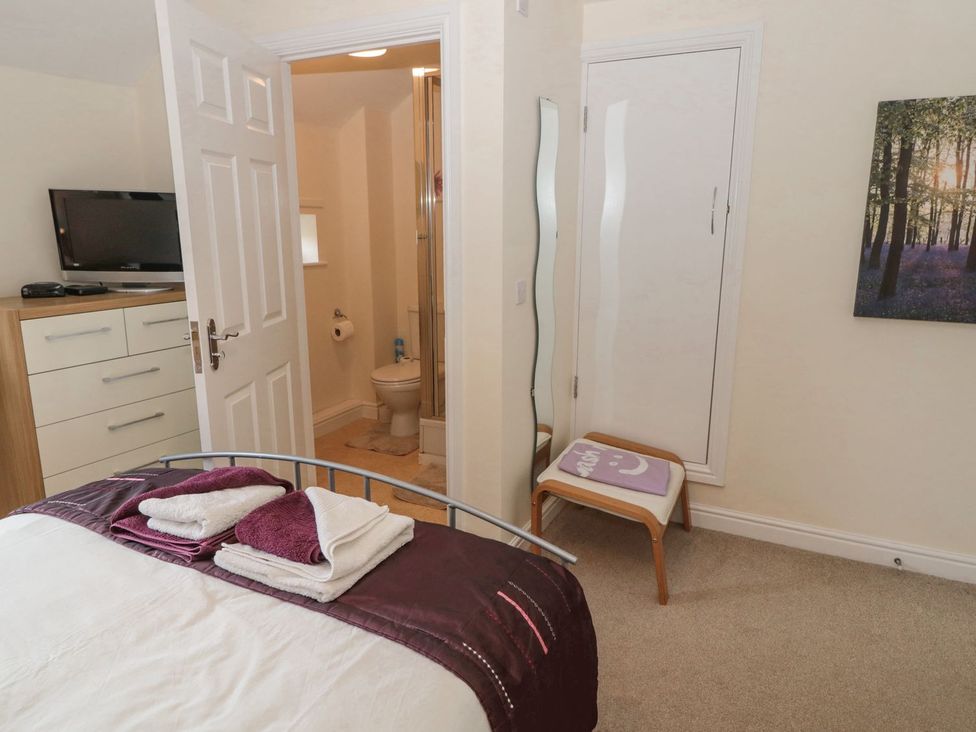 A bedroom with a bed and a bathroom in Ramblers Cottage Alnwick