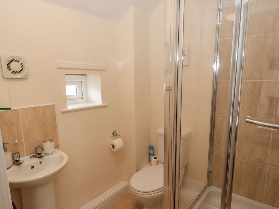 A bathroom featuring a shower, toilet, and sink at Ramblers Cottage in Alnwick