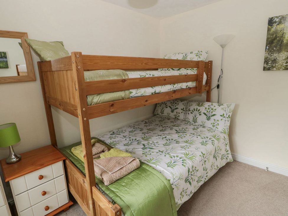 A bedroom with a bunk bed and double bed at Ramblers Cottage in Alnwick