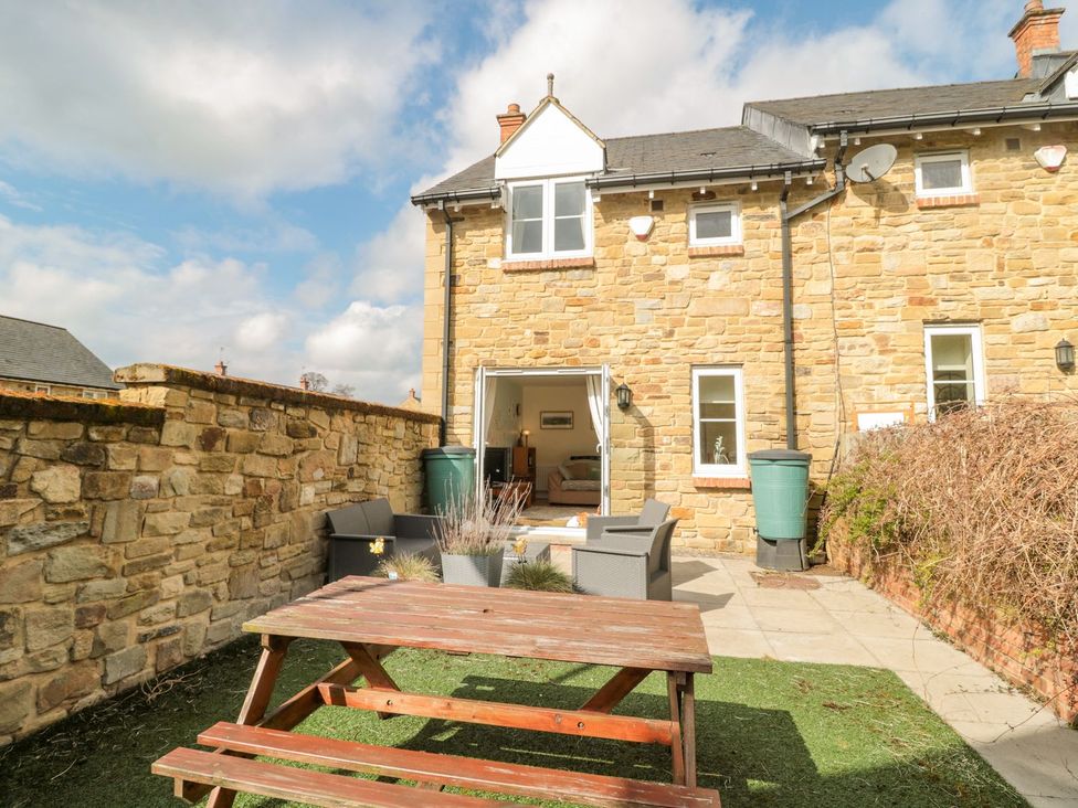 A garden with outdoor seating and table at Ramblers Cottage in Alnwick