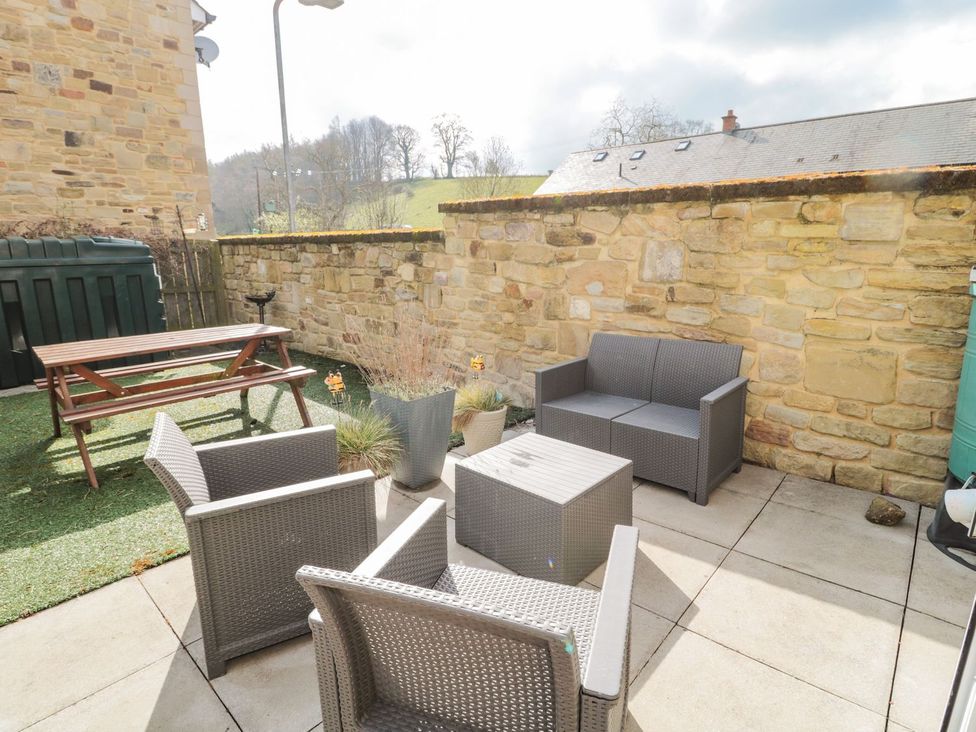 A garden with seating and a table at Ramblers Cottage in Alnwick
