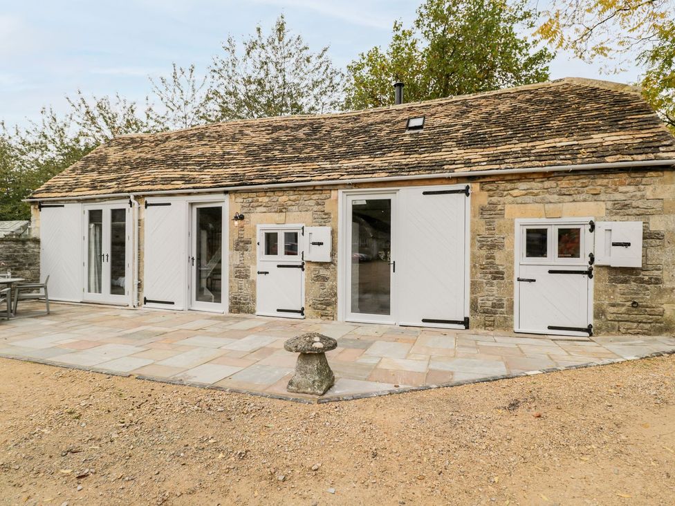 An outdoor area with a stone building and patio at The Old Swill House in Foxham
