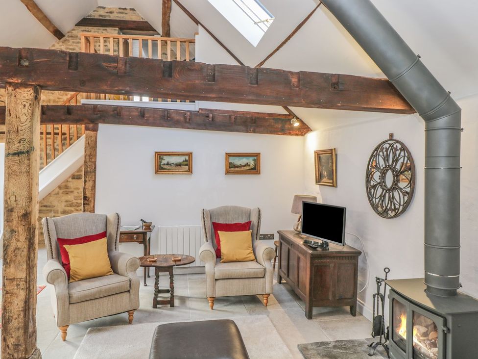 A living room with armchairs and a television at The Old Swill House in Foxham