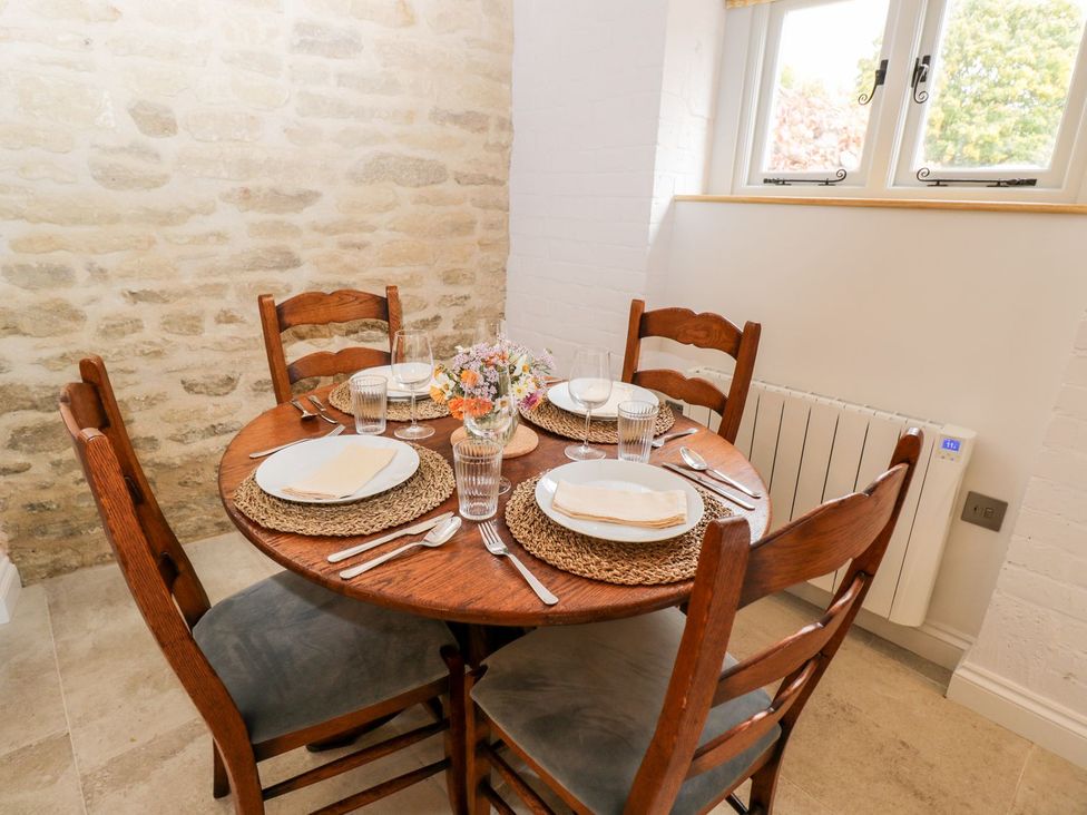 A dining room with a table set for meals at The Old Swill House in Foxham