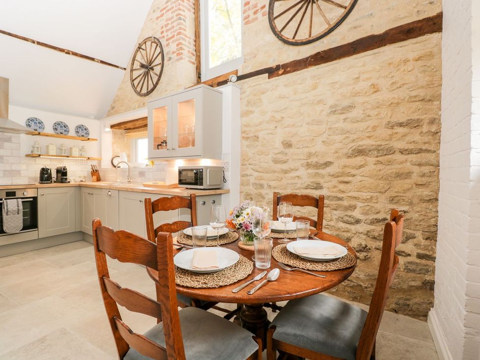 A kitchen with a dining table and chairs at The Old Swill House in Foxham