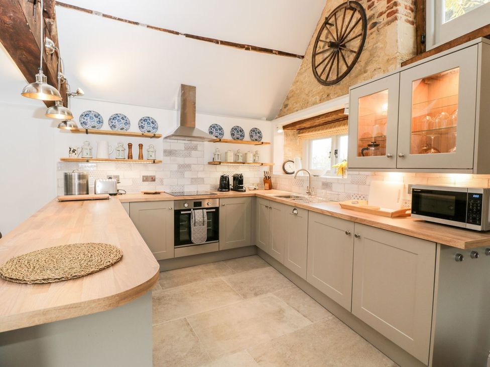 A kitchen with cabinets, countertop, sink and oven at The Old Swill House in Foxham