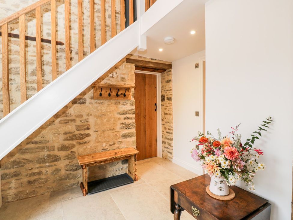 An entryway with a staircase and a flower vase at The Old Swill House in Foxham